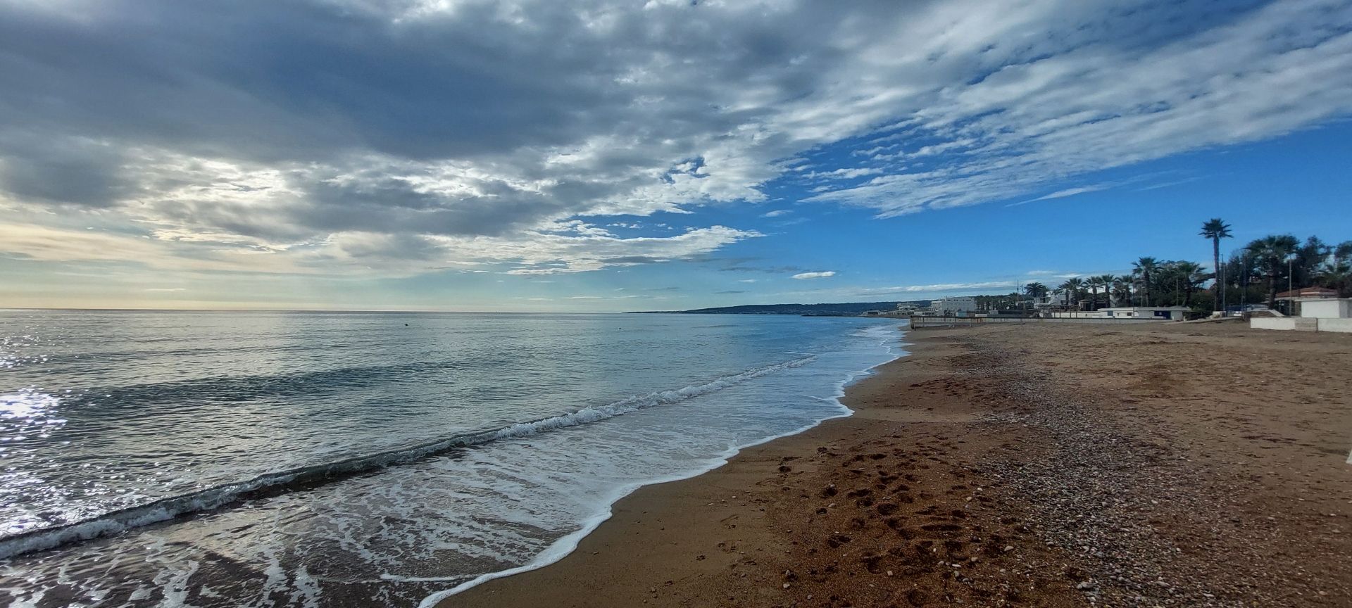 Il mare quasi al tramonto, jn basso la battigia, il mare e il cielo parzialmente nuvoloso.
The sea almost at sunset, the shoreline below, the sea and the partially cloudy sky.