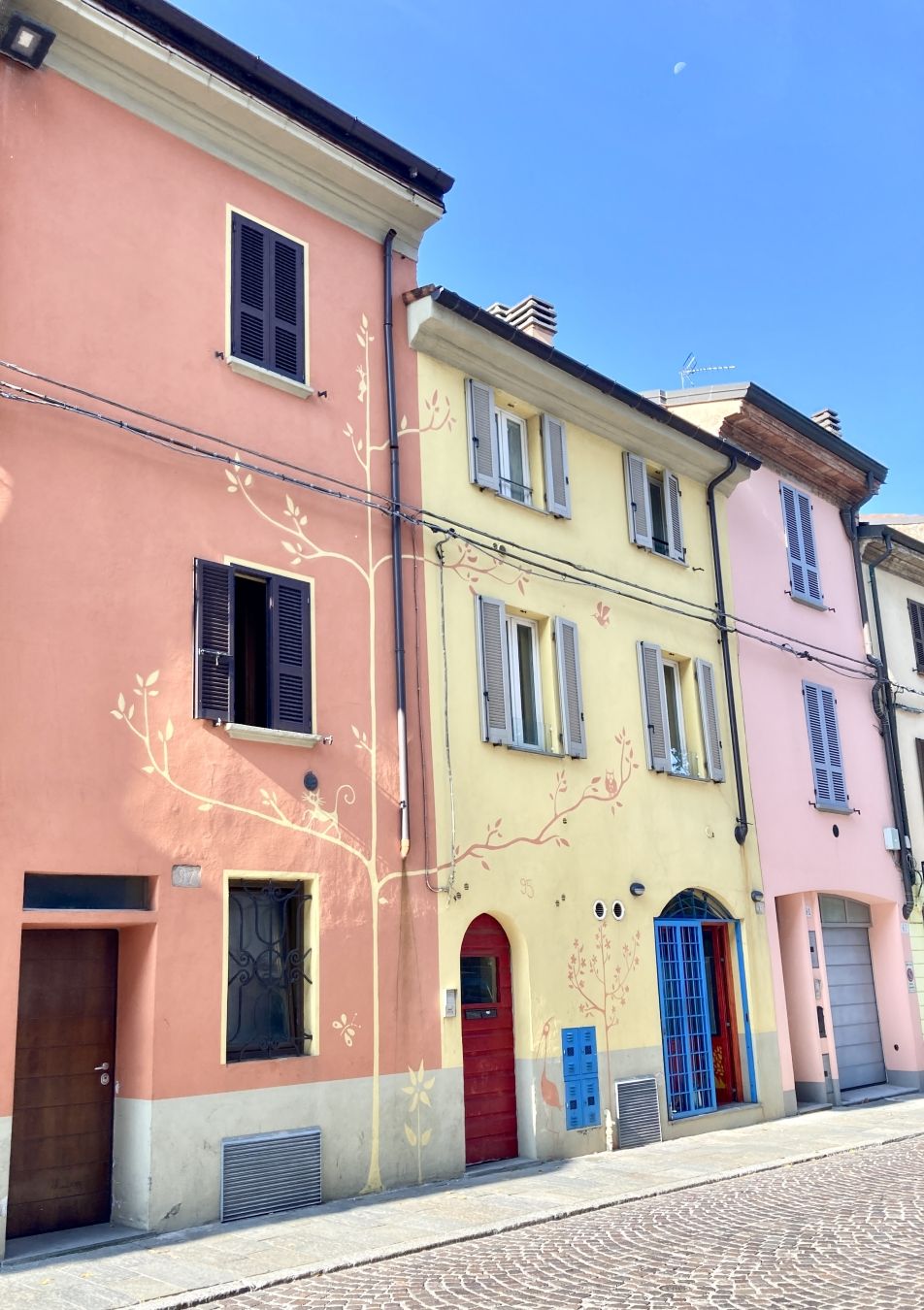 Muro esterno decorato con figure di alberi con gatti sopra. Via Alberoni, Piacenza