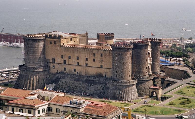 Castel Nuovo Napoli Bellissimo!
Dopo la sua costruzione a opera di Carlo I d’Angiò, durante la dominazione di Roberto d’Angiò la struttura divenne un punto cruciale per la cultura partenopea. Presso l’edificio erano infatti soliti soggiornare grandi artisti, medici e importanti autori letterari. Dopo la dominazione angioina iniziò quella degli Aragonesi.
Durante quel periodo storiche ci furono diverse modifiche che portarono il castello ad assumere una forma decisamente diversa rispetto a quella originaria. Durante il XV secolo fu la volta della dominazione a opera dei Francesi, ai quali subentrarono prima gli spagnoli e poi gli austriaci. Nei primi anni del XX secolo iniziarono invece i lavori che portarono il castello in una posizione isolata rispetto alle costruzioni che nel corso della storia vennero costruite intorno.
In questo modo la struttura assunse un enorme risalto, in particolare dal punto di vista paesaggistico. Si tratta di un castello che oggi si può visitare e che costituisce una parte fondamentale durante un viaggio a Napoli.